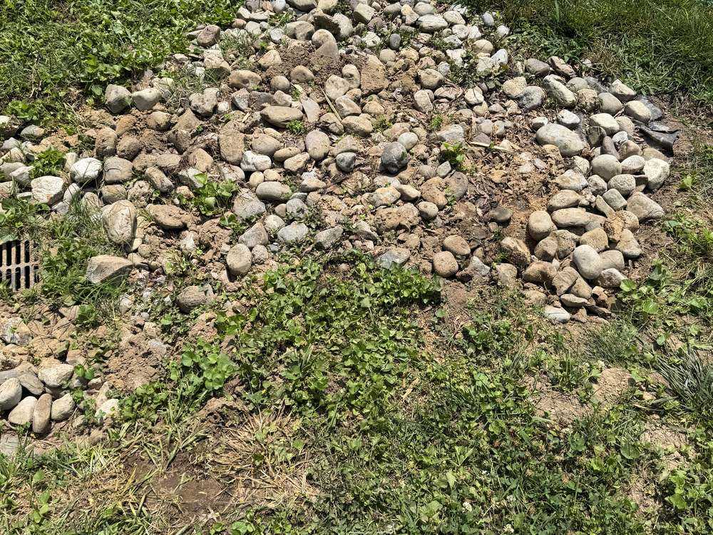 Restored river-rock drainage bed after concrete footing removal in Annapolis, MD