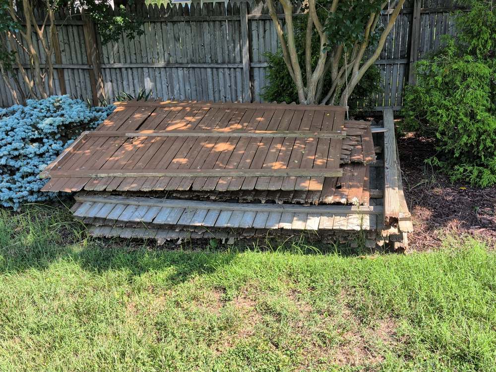 Stacked sections of demolished wooden fence panels before haul away in Annapolis, MD