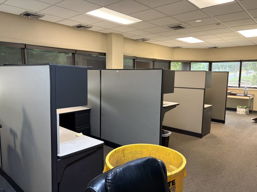 Dismantled desk frames and e-waste piled during an office cleanout in Annapolis, MD