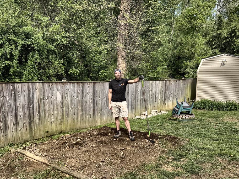 Bare dirt pad along the fence after chicken coop removal in Arnold, MD