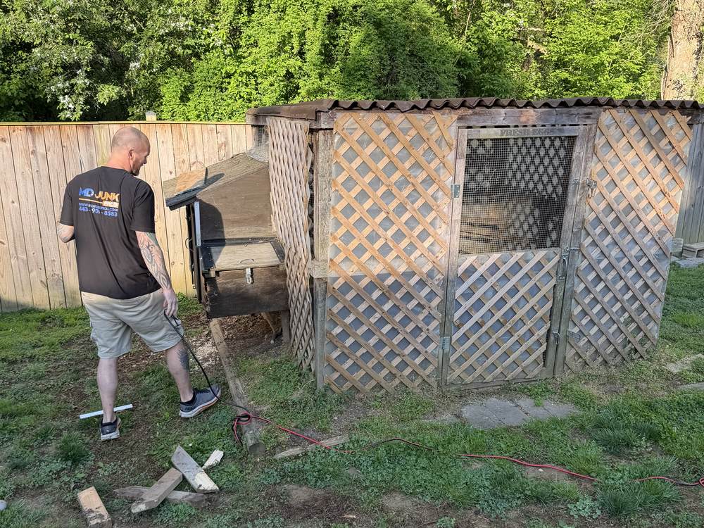 Large wooden chicken coop with lattice panels before removal in Arnold, MD