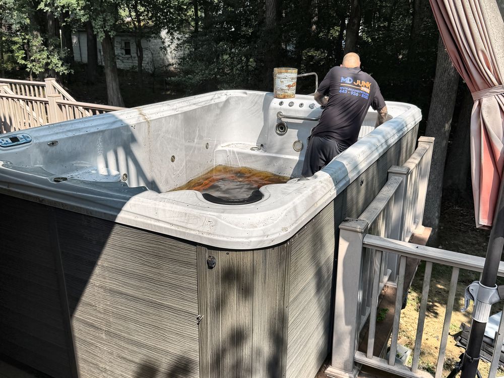 MD Junk Pros crew draining down an old swim spa on a deck during removal in Clarksville, MD