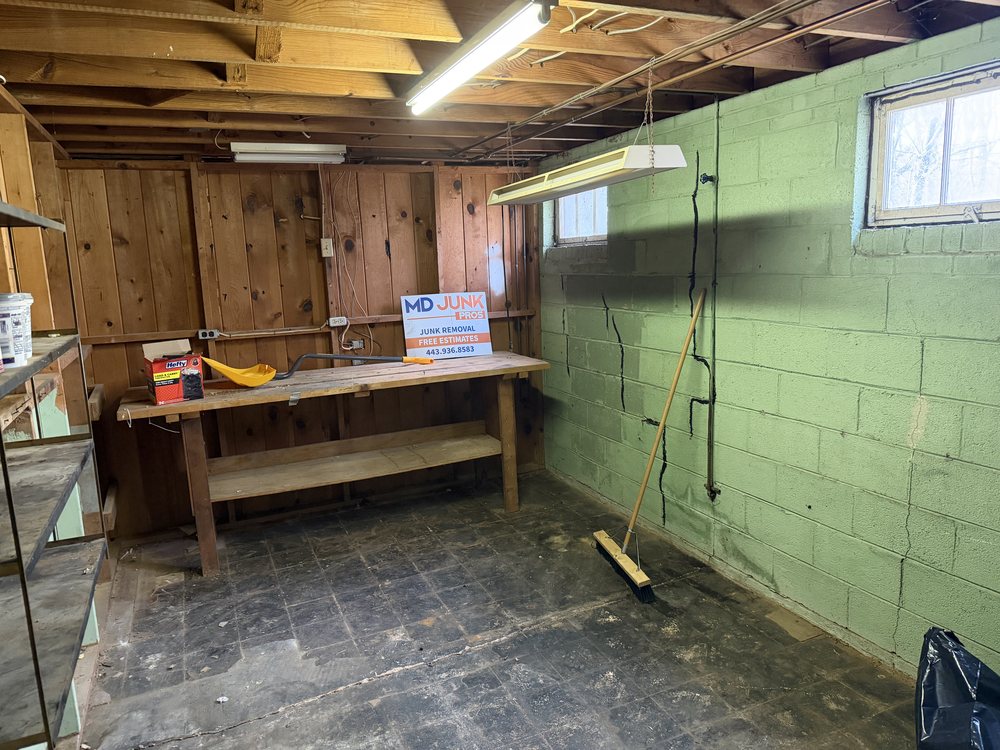 Same basement workbench area cleared and swept with an MD Junk Pros sign after the cleanout on Carlinda Avenue in Columbia, MD