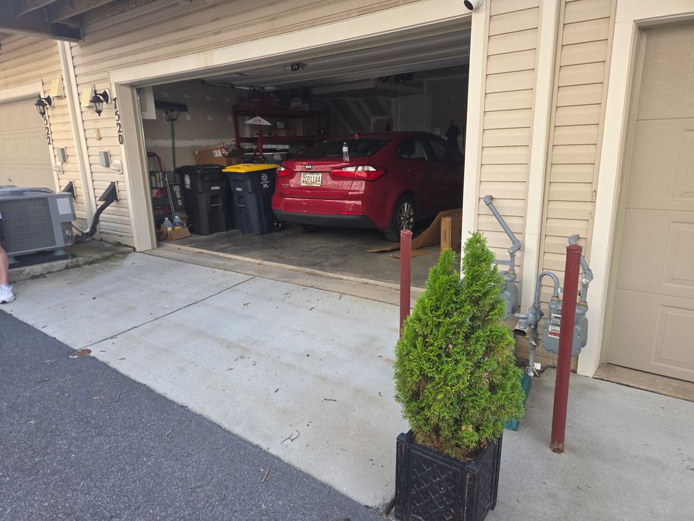 Cleared two-car garage with the car parked back inside after a garage cleanout in Crofton, MD