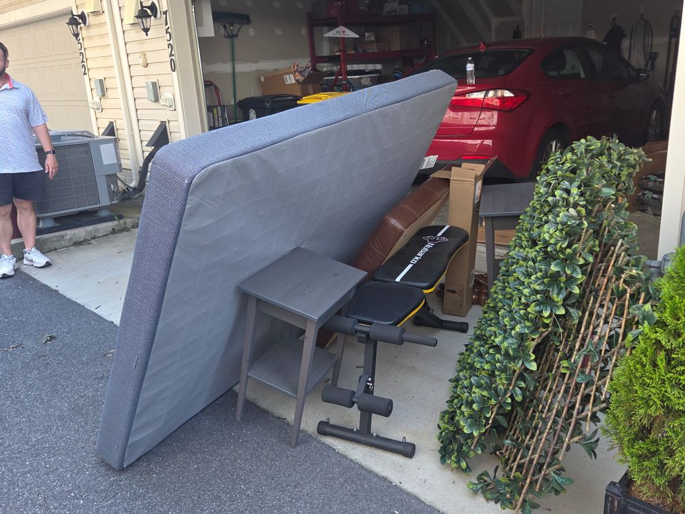 Mattress, weight bench, side table and artificial hedges pulled out of a townhome garage during a cleanout off Route 3 in Crofton, MD
