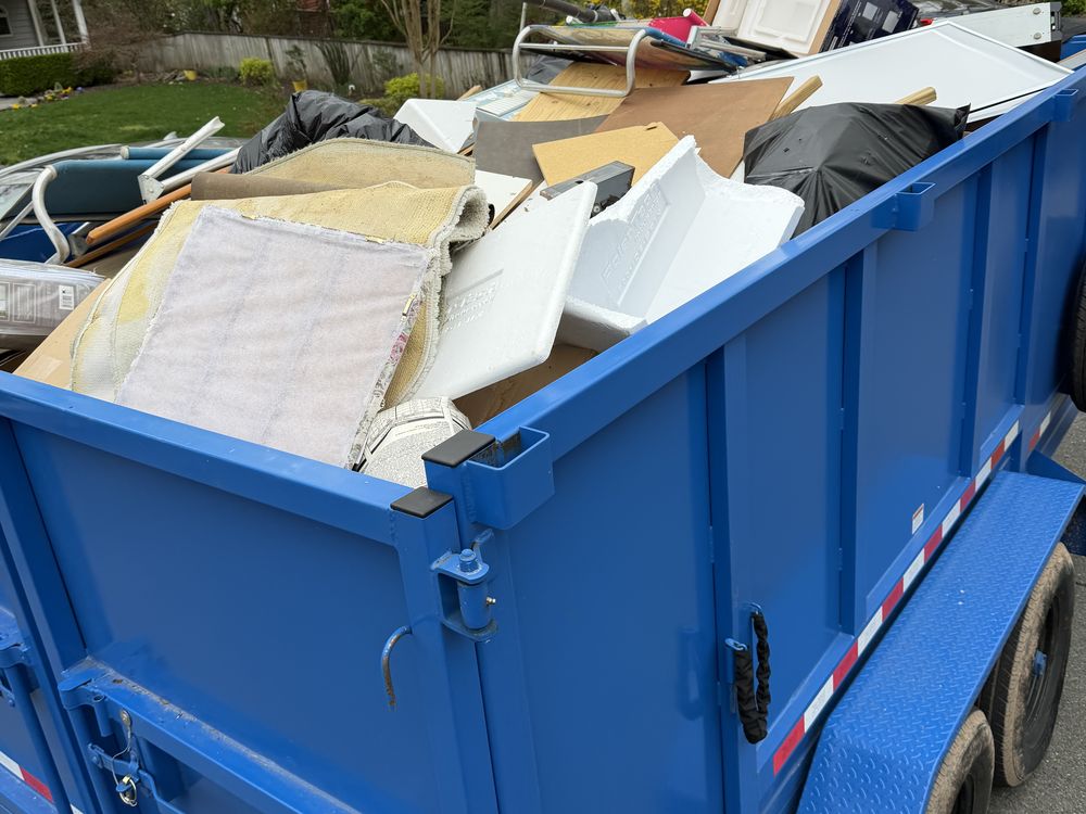 Dump trailer loaded with carpet, board and household debris after an estate cleanout in Edgewater, MD