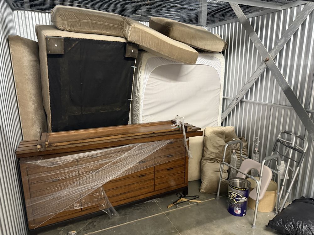 Storage unit packed with a mattress, dresser, headboard and medical equipment before cleanout in Edgewater, MD