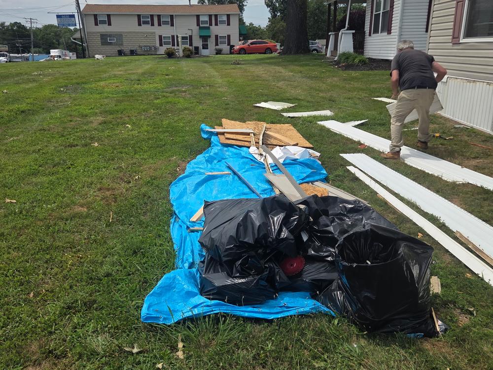 Old siding, wood and drywall piled on a tarp before a construction debris haul-off on Washington Boulevard in Elkridge, MD