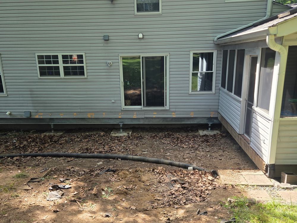 Bare ground against the house where a deck stood after demolition in Ellicott City, MD