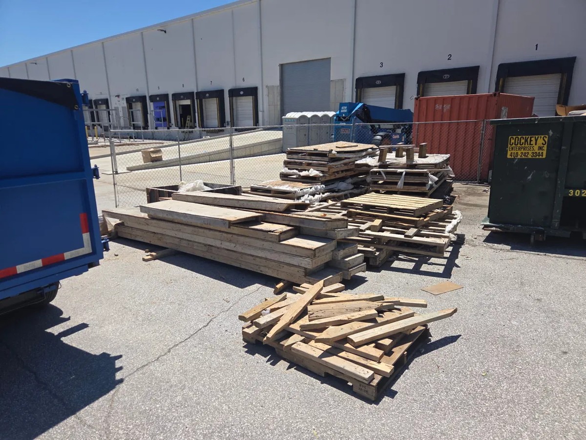 Stacked wood pallets and construction debris by the loading docks at a Gambrills business park off Benfield Boulevard before commercial junk removal