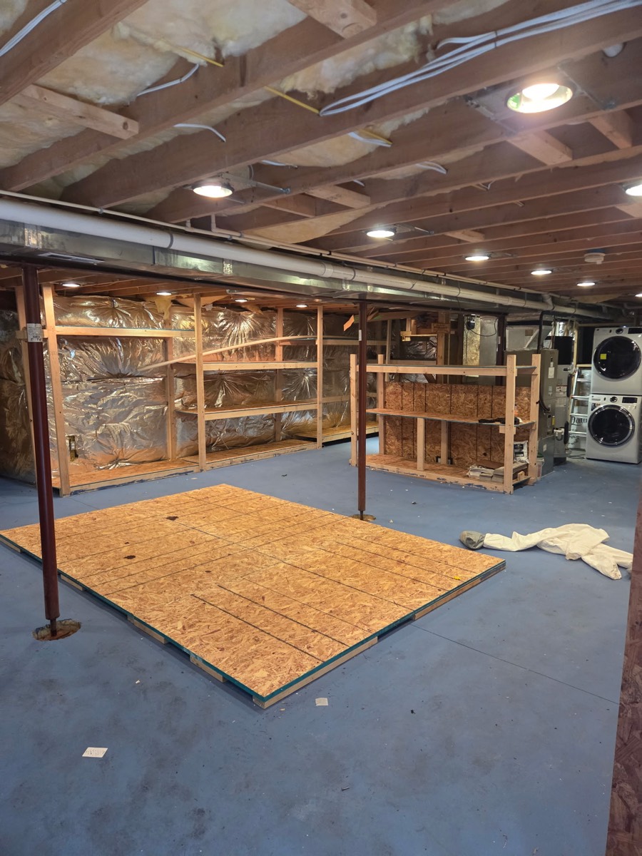 Cleared basement with open floor space and emptied wooden shelving after an estate cleanout on Kennard Drive in Glenelg, MD