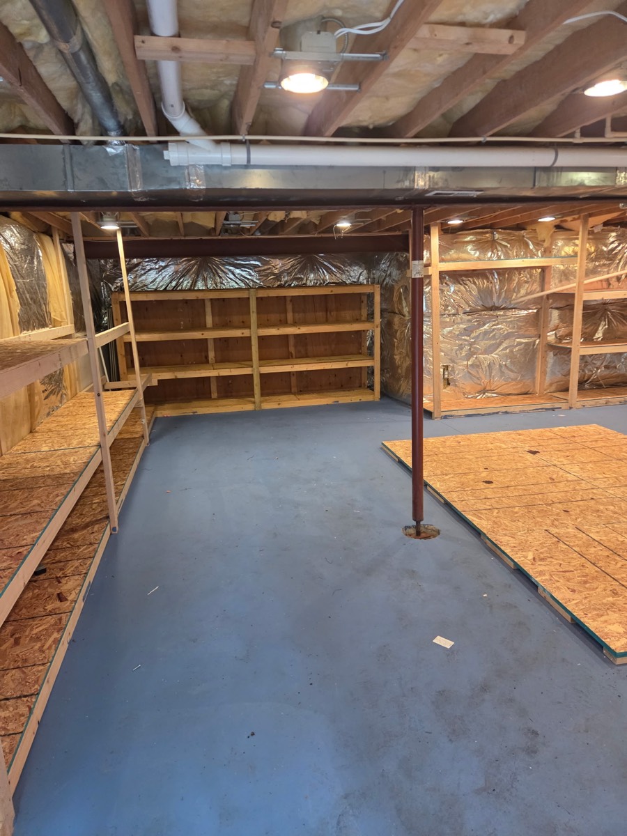 Second cleared view of the basement with empty storage shelves after an estate cleanout on Kennard Drive in Glenelg, MD