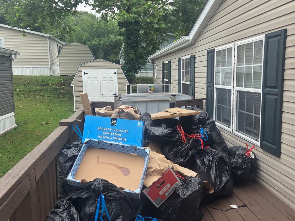 Deck piled with bagged household junk and boxes before a porch cleanup on Linda Place in Hanover, MD