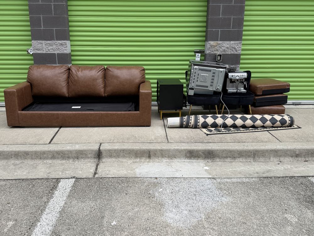 Leather sofa, TV console, espresso machine and rug pulled out of a storage unit before a cleanout on Fort Meade Road in Laurel, MD