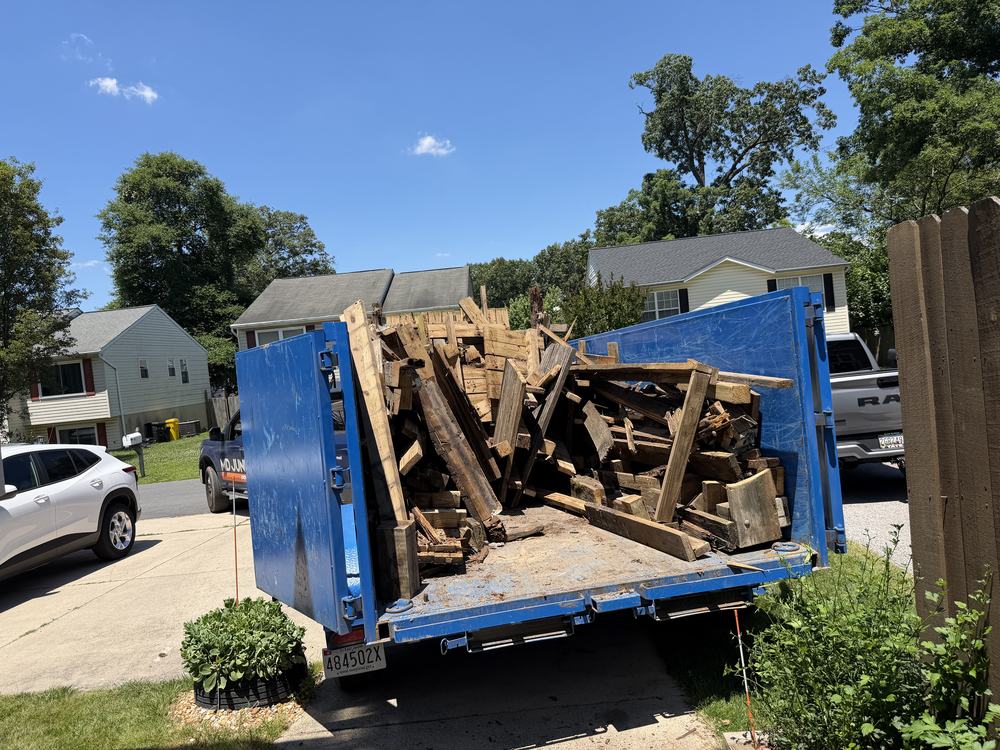Dump trailer loaded with framing and decking after a deck teardown in Pasadena, MD