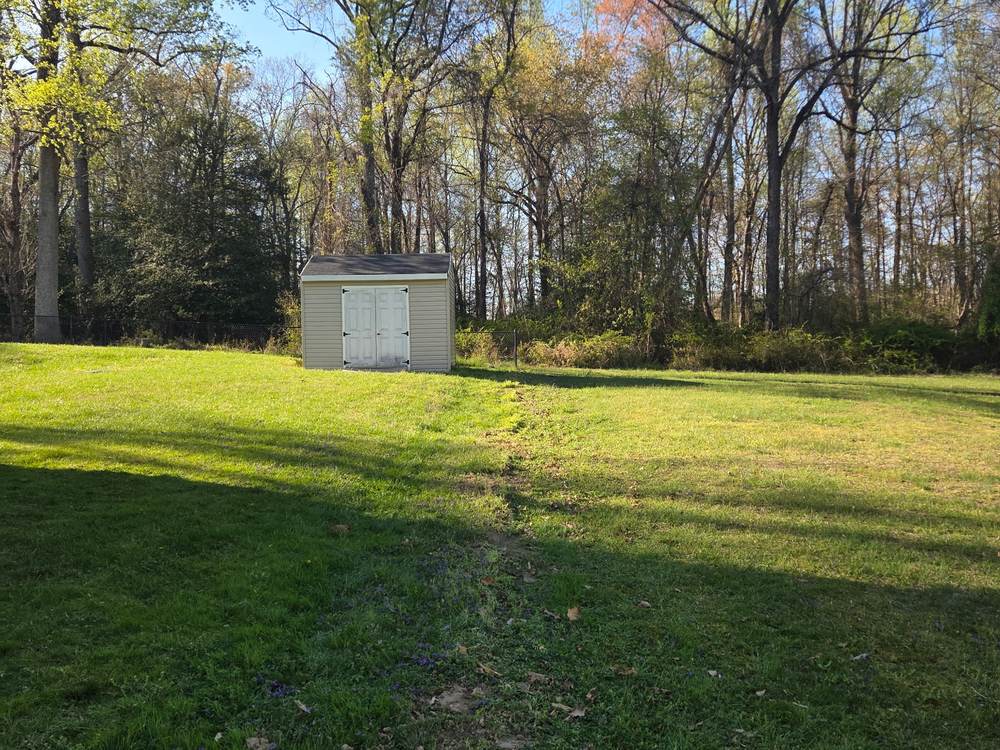 Open lawn cleared of fence sections after removal in Pasadena, MD