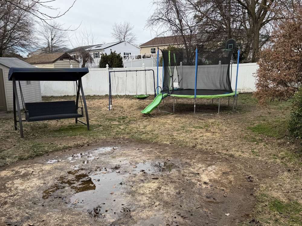 Cleared backyard where an above-ground pool stood after removal in Pasadena, MD