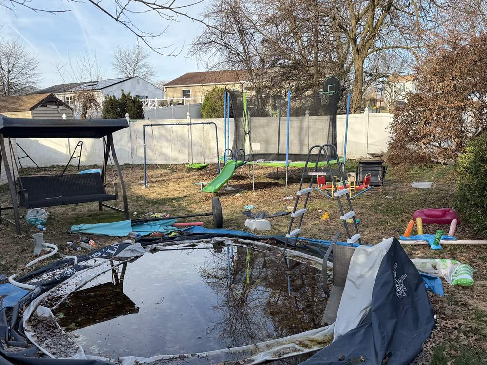 Collapsed above-ground pool holding standing water before removal in Pasadena, MD