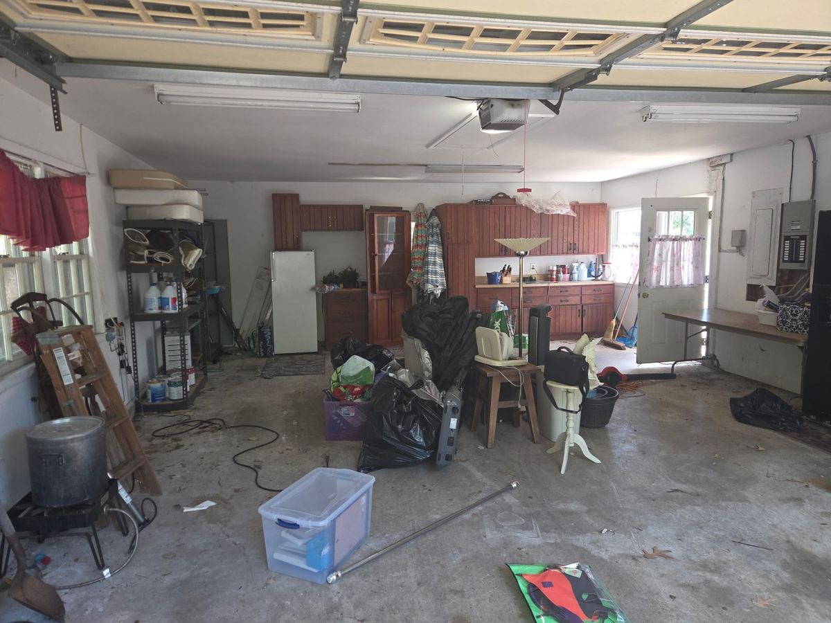 Cluttered two-car garage packed with boxes and furniture before a junk removal cleanout in Severna Park, MD